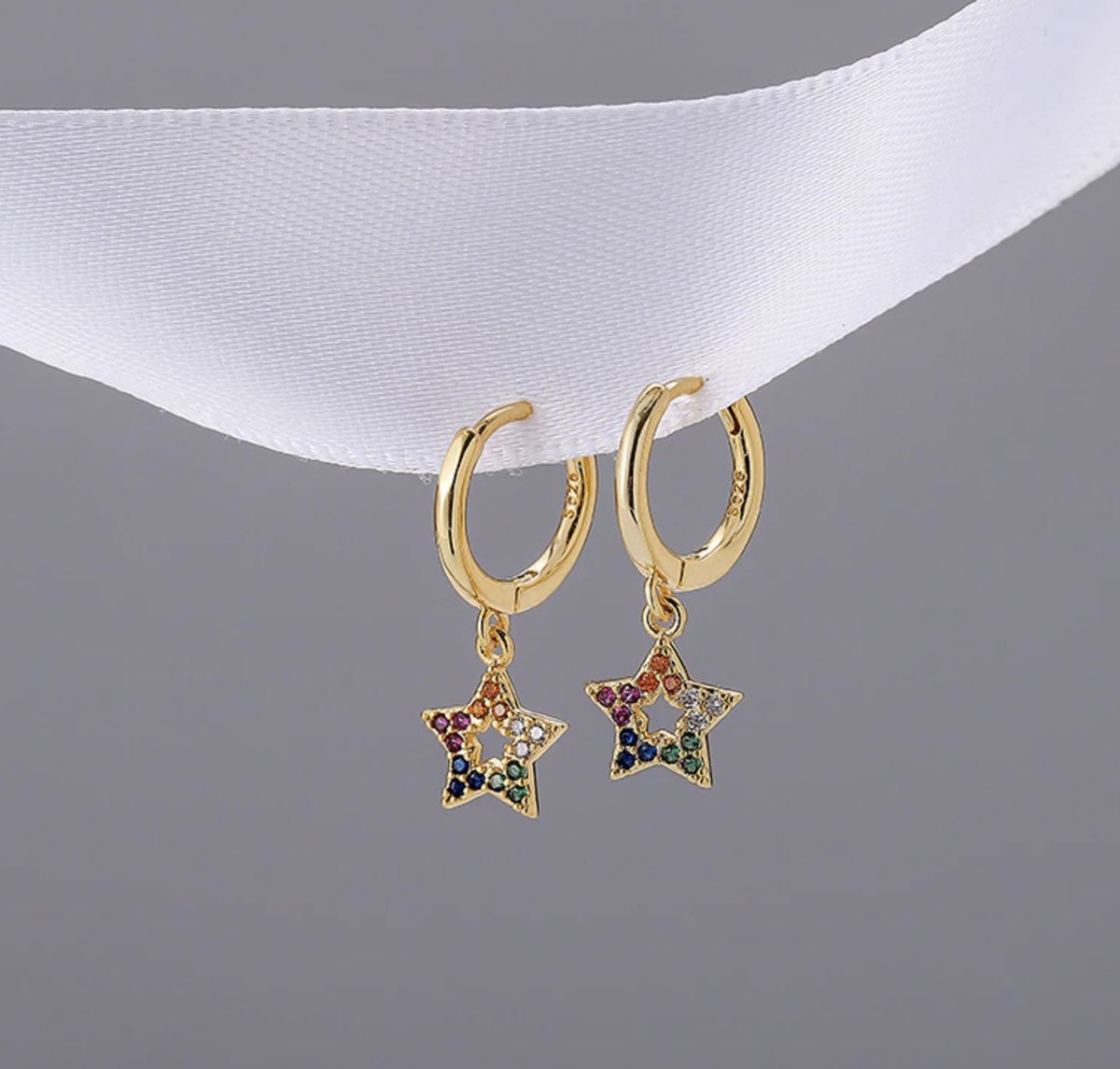 ster oorbellen ingelegd met steentjes, goud